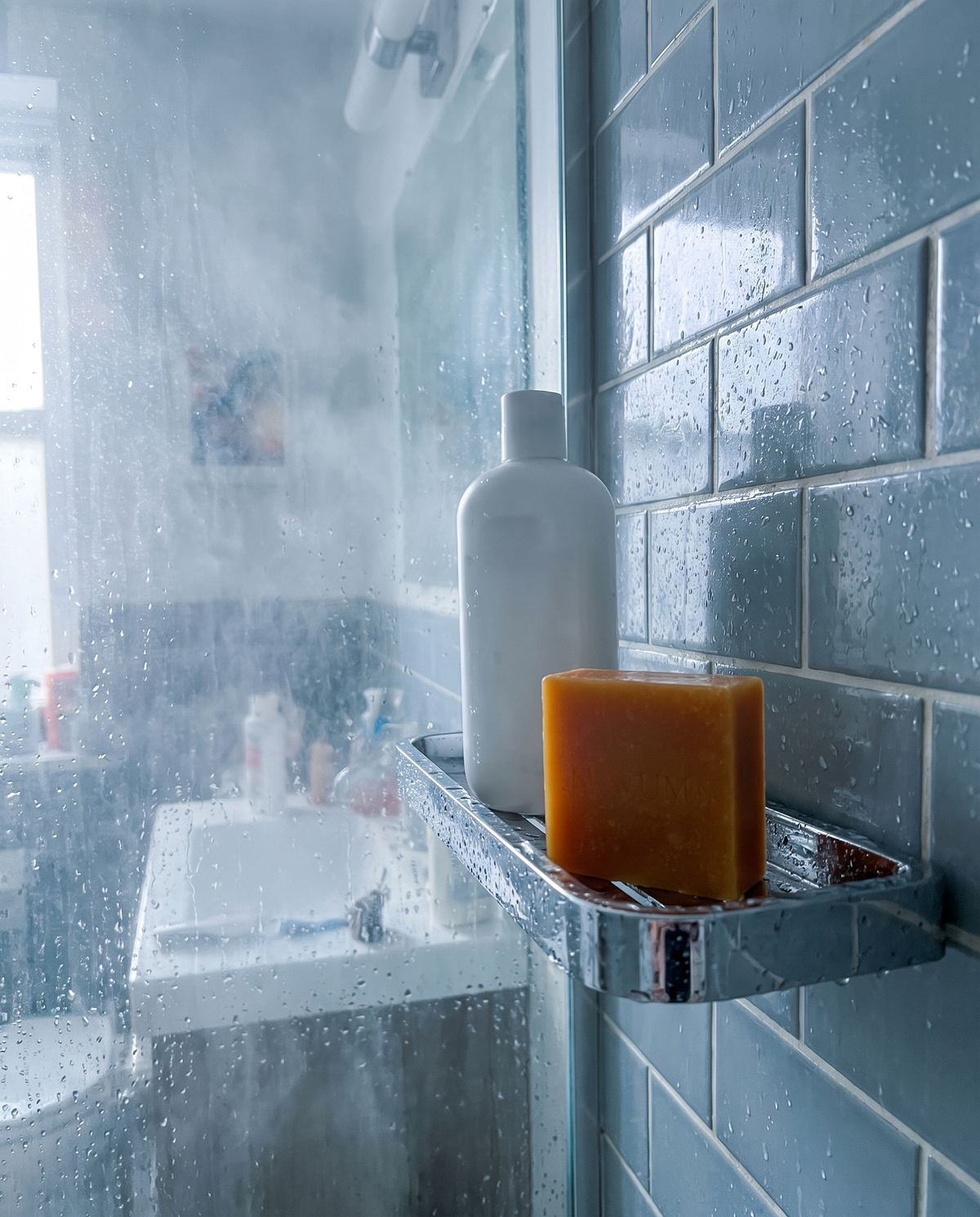 An amber soap bar on a wet shower shelf