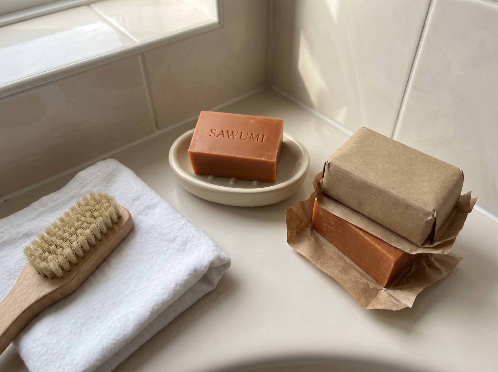 Three SAWUMI persimmon bars on the bathroom shelf